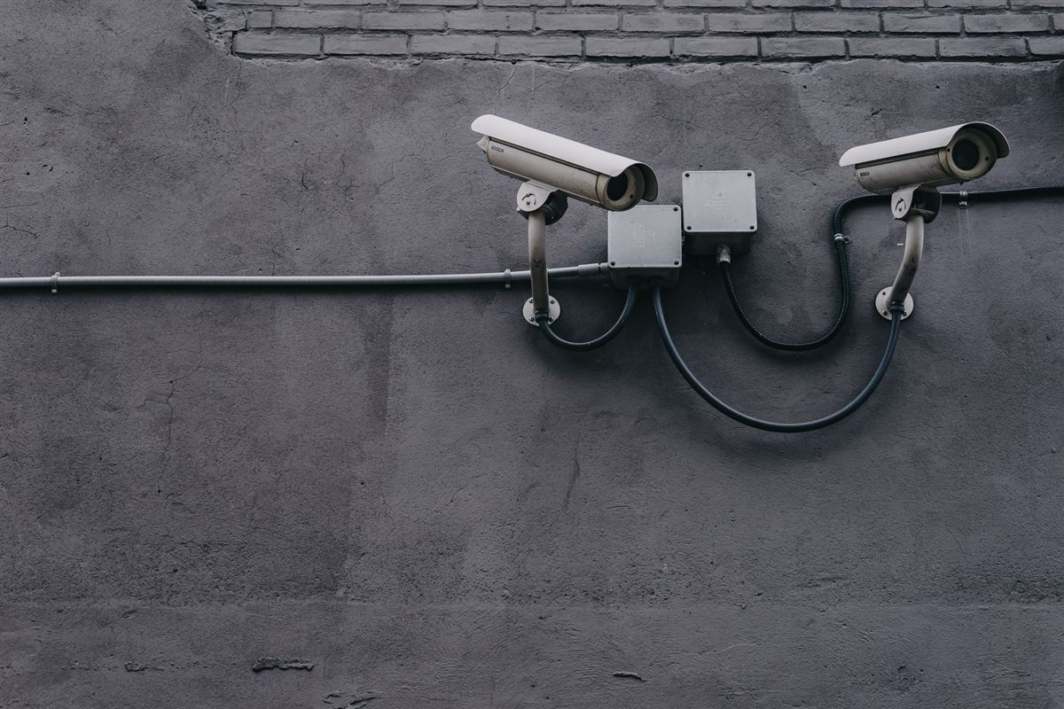 Two surveillance cameras mounted on a concrete wall
