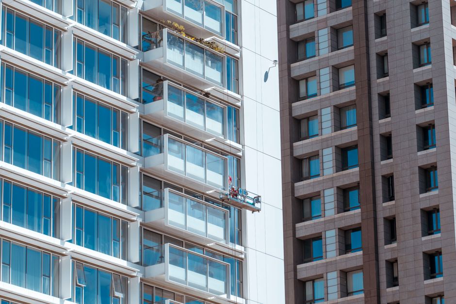 A suspended work platform beside the balconies of an apartment building