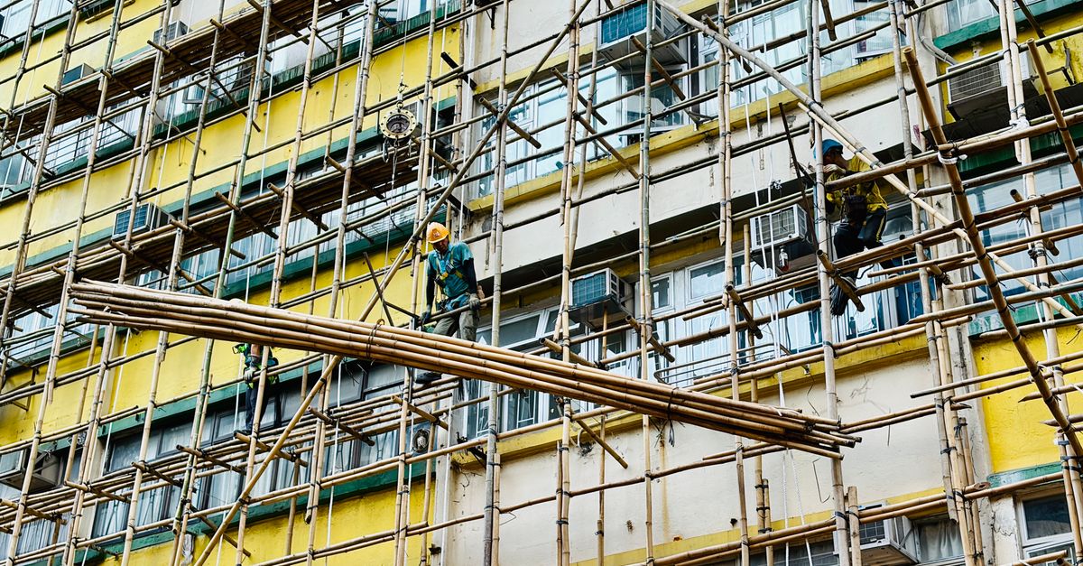 Workers repairing the exterior of an apartment building