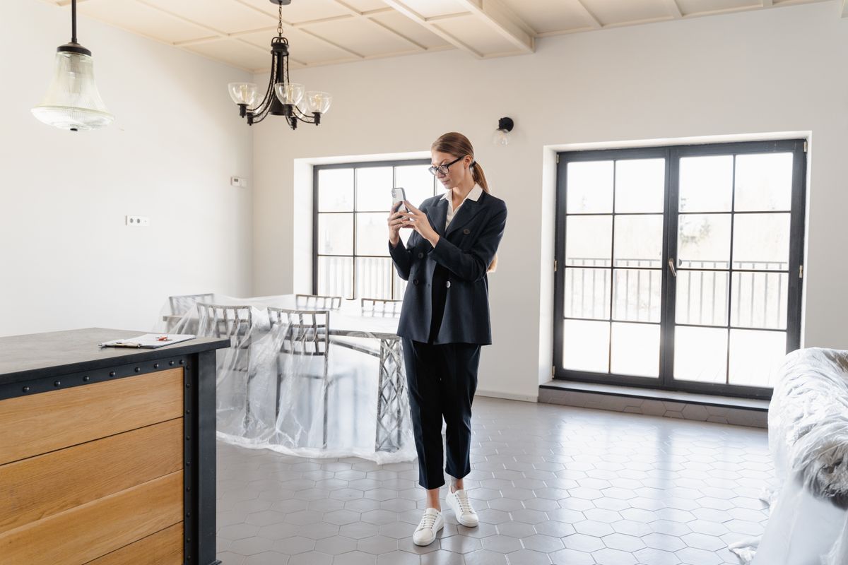 A person photographing a room on a phone while documenting a property